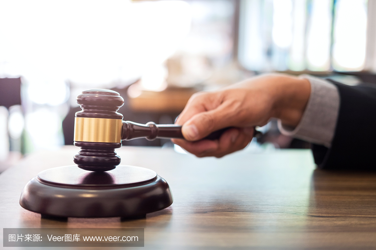 男律师或法官手敲着木槌,在法庭上工作,法律和正义的概念